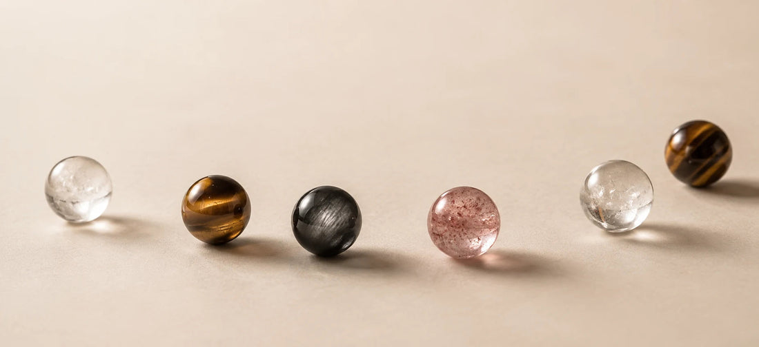 A restrained Strandzen material study with pink, clear, dark, and tiger eye beads in soft light