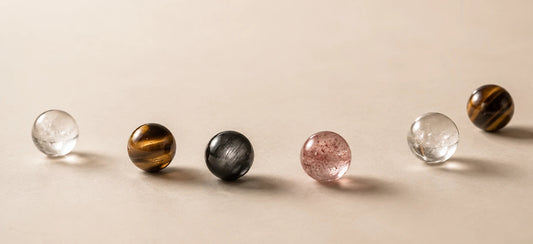 A restrained Strandzen material study with pink, clear, dark, and tiger eye beads in soft light