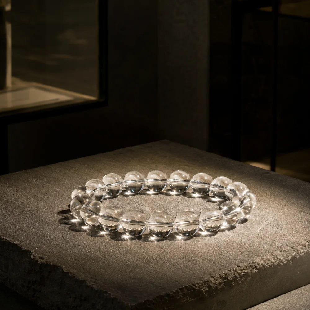 A clear quartz bracelet photographed in direct natural light, showing transparency and visible internal variation