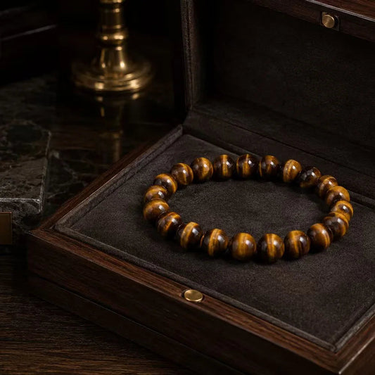 A tiger eye bracelet material study showing natural golden bands across polished brown beads