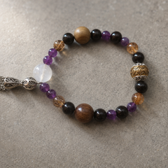 Night Anchor finished crystal bracelet in black, purple, amber-brown, and warm wood tones thumbnail