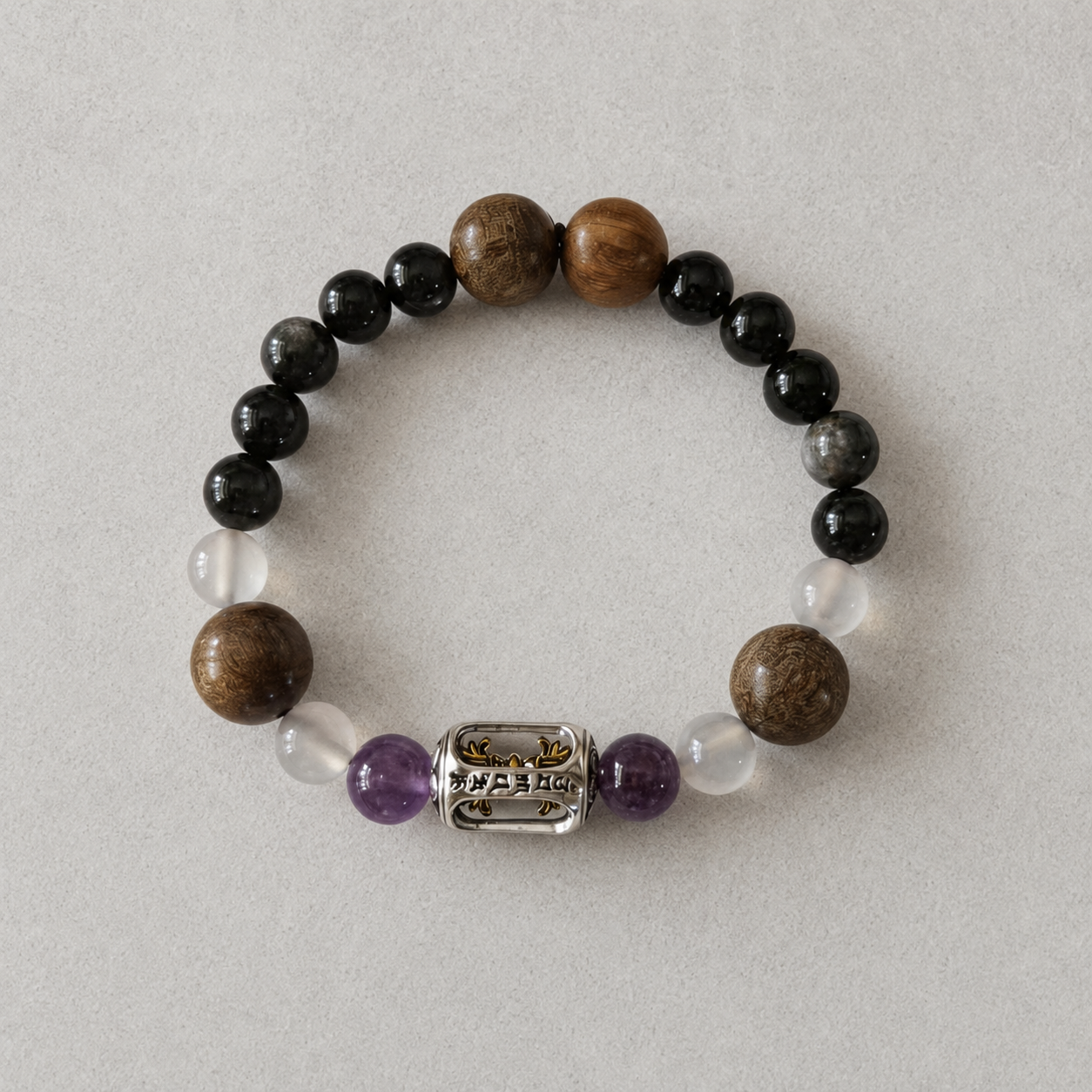 Double Guard Plan A bracelet with black, clear, white, purple, warm brown, and silver-tone details on light stone