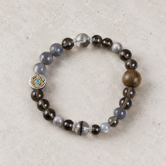 Double Guard Plan B bracelet with smoky brown, blue-gray, clear, warm brown, silver-tone, and turquoise-blue details on light stone