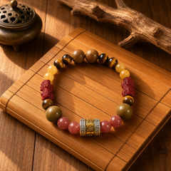 Lotus Start New Start crystal bracelet on a bamboo mat with wood, tiger eye, yellow beads, red carved accents, and a gold focal bead thumbnail