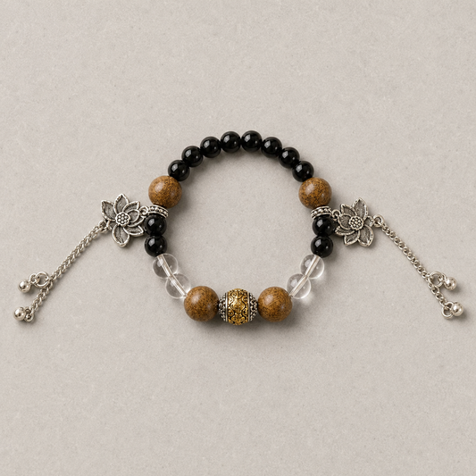 Still Ground Plan A bracelet with black, warm brown, clear, and silver-tone details on light stone